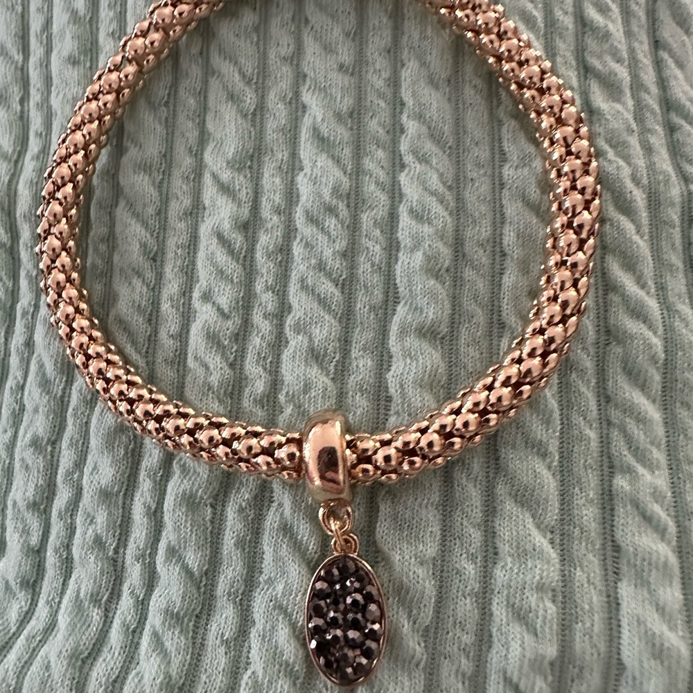 Gold and Black Braided Bracelet with Intricate Charm